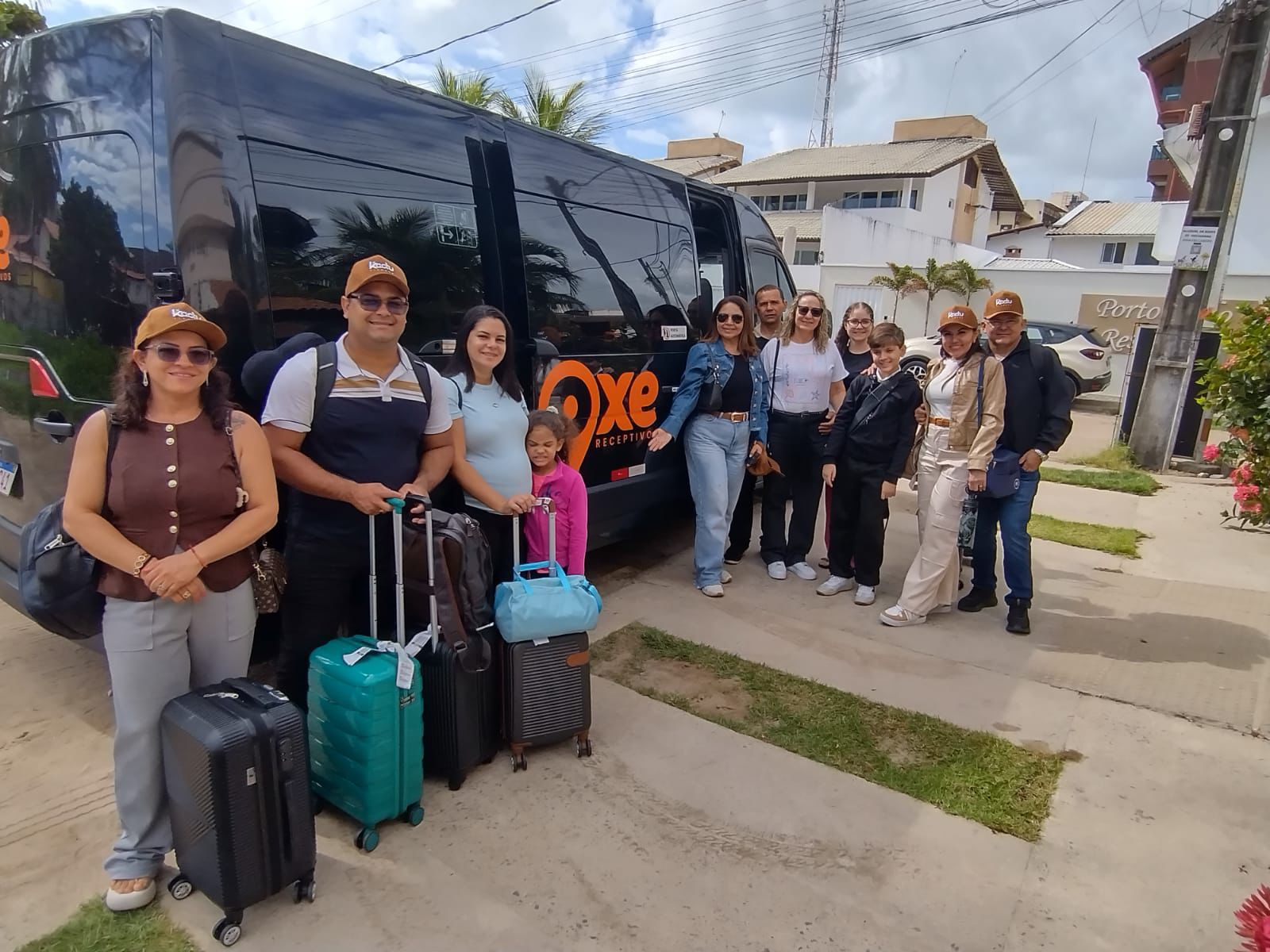 Grupo de passageiros com a van OXE em destino